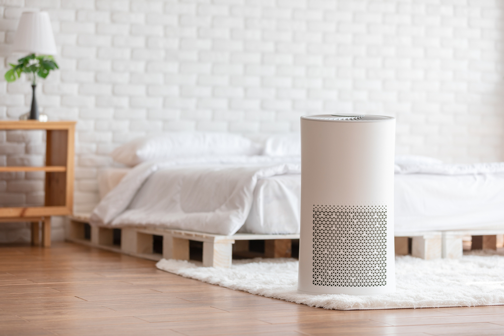 air purifier in a white cosy bedroom